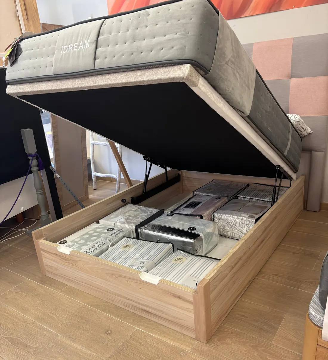 Canapé abatible de madera abierto con ropa de cama guardada, en la tienda ZIHOUSE de Lugo